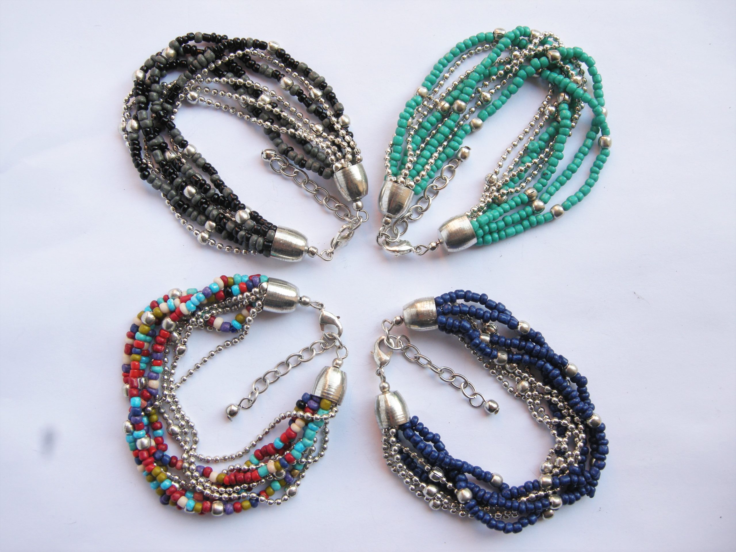Bracelet fil mémoire , perles de rocailles multicolores et petits grelots .  - Un grand marché